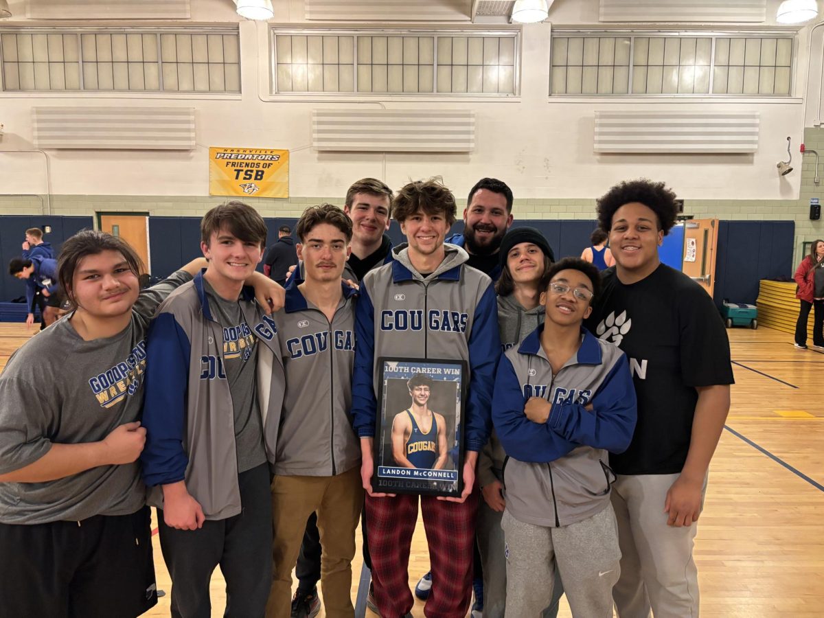 McConnell poses with the wrestling team with his 100 career win photo.