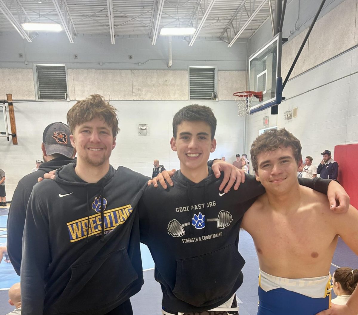 Landon McConnell, Levi McConnell, and a coach posing after a wrestling match this weekend.